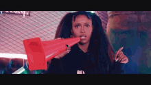 a woman is holding a red traffic cone in her hand