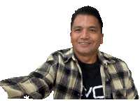 a man wearing a plaid shirt and a vc shirt smiles