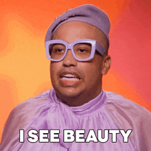 a man wearing glasses and a purple shirt with the words i see beauty below him