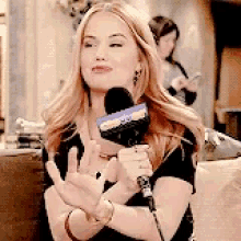 a woman is holding a microphone and making a funny face