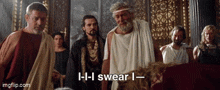 a group of men are standing in a room and one of them is saying i - i swear i - i