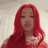 a woman with red hair and a nose ring is looking down .