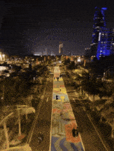 an aerial view of a street at night with palm trees and a building that says ' chase ' on it in the background