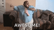 a man is sitting on a couch with his arms outstretched and the words `` awesome '' written on the screen .