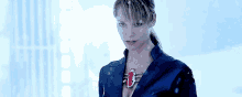 a woman is wearing a blue jacket and a red necklace .