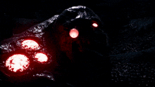a purple light is surrounded by red lights in a dark room