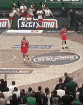 a basketball game is being played in front of a crowd with a sign that says stoxima