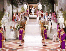 a group of men in purple uniforms stand in front of a staircase with balloons
