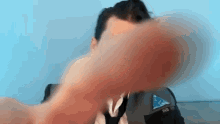 a man in a suit and tie is taking a selfie with his hand
