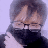 a person wearing glasses and a black mask