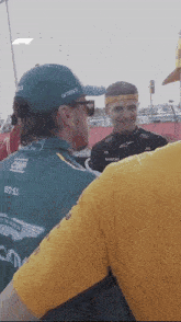 a man wearing a hat that says omp on it is talking to another man
