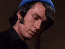a man wearing a black shirt and a blue hat