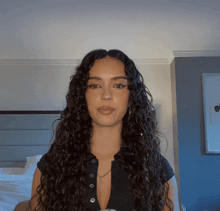 a woman with curly hair and a cross necklace