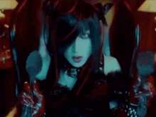 a woman with long black hair is sitting in a chair in a dark room holding a knife .