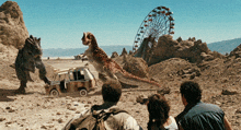 a group of people looking at a ferris wheel and a dinosaur in the desert