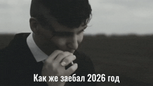 a man in a suit and tie smoking a cigarette with the year 2026 on the bottom