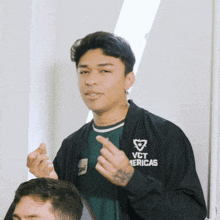 a man wearing a black jacket that says vct americas on it