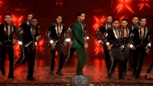 a man in a green suit is surrounded by men in black suits