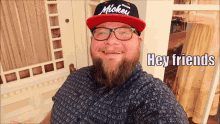 a man with a beard wears a mickey hat and glasses