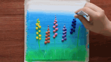 a person is drawing flowers with a marker on a piece of paper