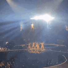 a group of people are dancing on a stage in front of a sign that says xxx