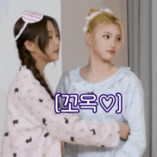 two girls are hugging each other in a room with korean writing on the bottom