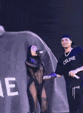a man and a woman are standing next to each other on a stage .