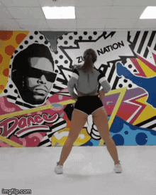 a woman is dancing in front of a wall that says " dance "