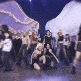 a group of women are dancing on a stage