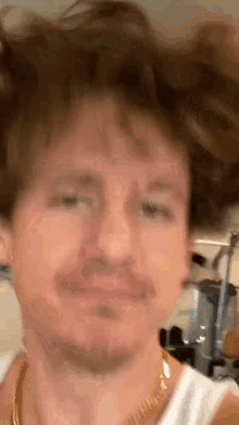 a close up of a man 's face with his hair in the air .