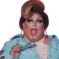 a drag queen is wearing a blue jacket and holding a pair of glasses in her hand