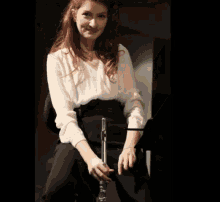 a woman sitting on a chair holding a flute in her hand