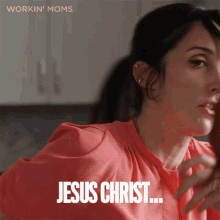 a woman in a pink shirt says " jesus christ " in black letters