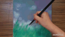 a person is painting on a canvas with the words made in animatica visible