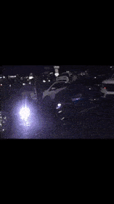 a group of cars are parked in a dark parking lot at night