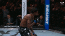 a man in a boxing ring with a budlight sign in the background