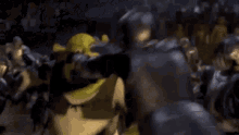 shrek is standing in a room with a bunch of people .