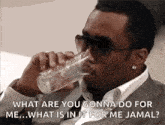 a man in a suit and sunglasses is drinking a glass of water and asking what are you gonna do for me .