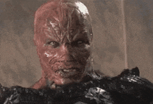 a close up of a demon 's face with horns and a very angry look on his face .