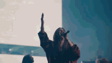 a woman singing into a microphone in front of a crowd