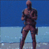 a man in a deadpool costume is standing in front of a blue wall .
