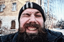 a man with a beard is making a funny face .