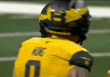 a football player wearing a helmet and a yellow jersey with the number 10 on it