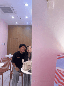 a man wearing a t-shirt that says studios takes a picture of himself and his girlfriend
