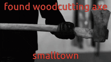 a black and white photo of a person holding a large axe with the words found woodcutting axe smalltown on the bottom