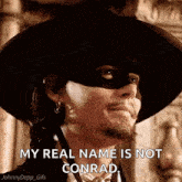 a man in a cowboy hat and mask is saying `` my real name is not conrad '' .