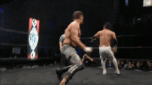 two men are wrestling in a ring with a sign that says rc