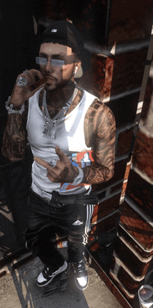 a man with a tattoo on his arm is wearing a tank top and a hat with the letter c on it
