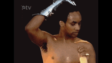 a man without a shirt is holding a banana in front of an otv sign