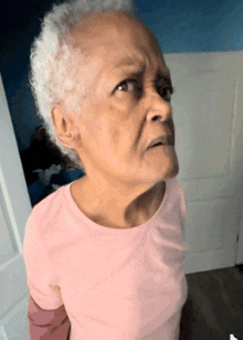 a woman in a pink shirt is making a face